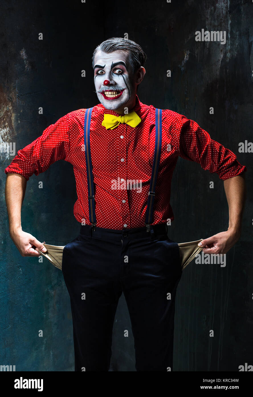 Terrible et clown Halloween theme : Crazy red clown dans une chemise avec  bretelles sur fond sombre Photo Stock - Alamy