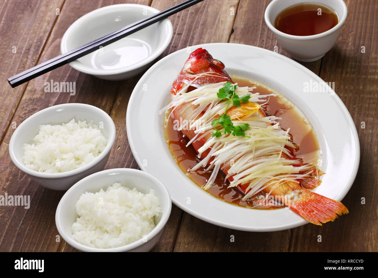 Mérou rouge cuit à la chinoise avec le gingembre, les échalotes et la sauce soja Banque D'Images