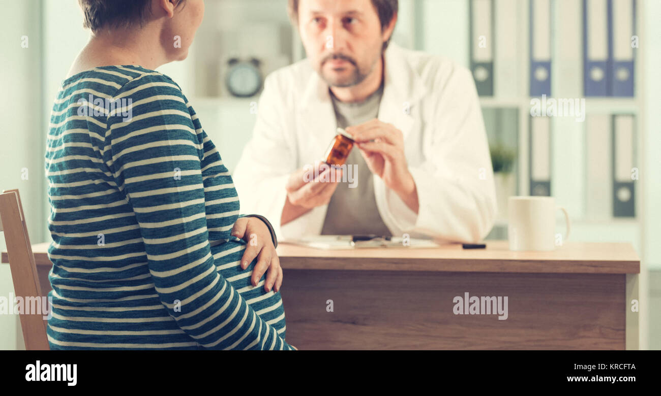 Médecin prescrivant comprimés pour femme enceinte. Soins de santé et aux médicaments pendant la grossesse. Banque D'Images