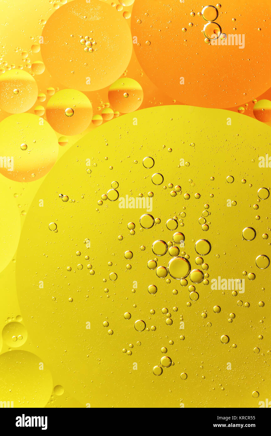 Des gouttelettes d'huile d'orange et jaune sur l'eau Banque D'Images