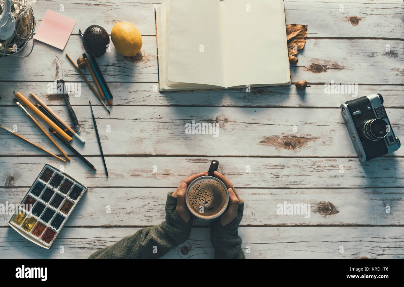 Fille avec une tasse de café et d'un espace de travail créatif Banque D'Images