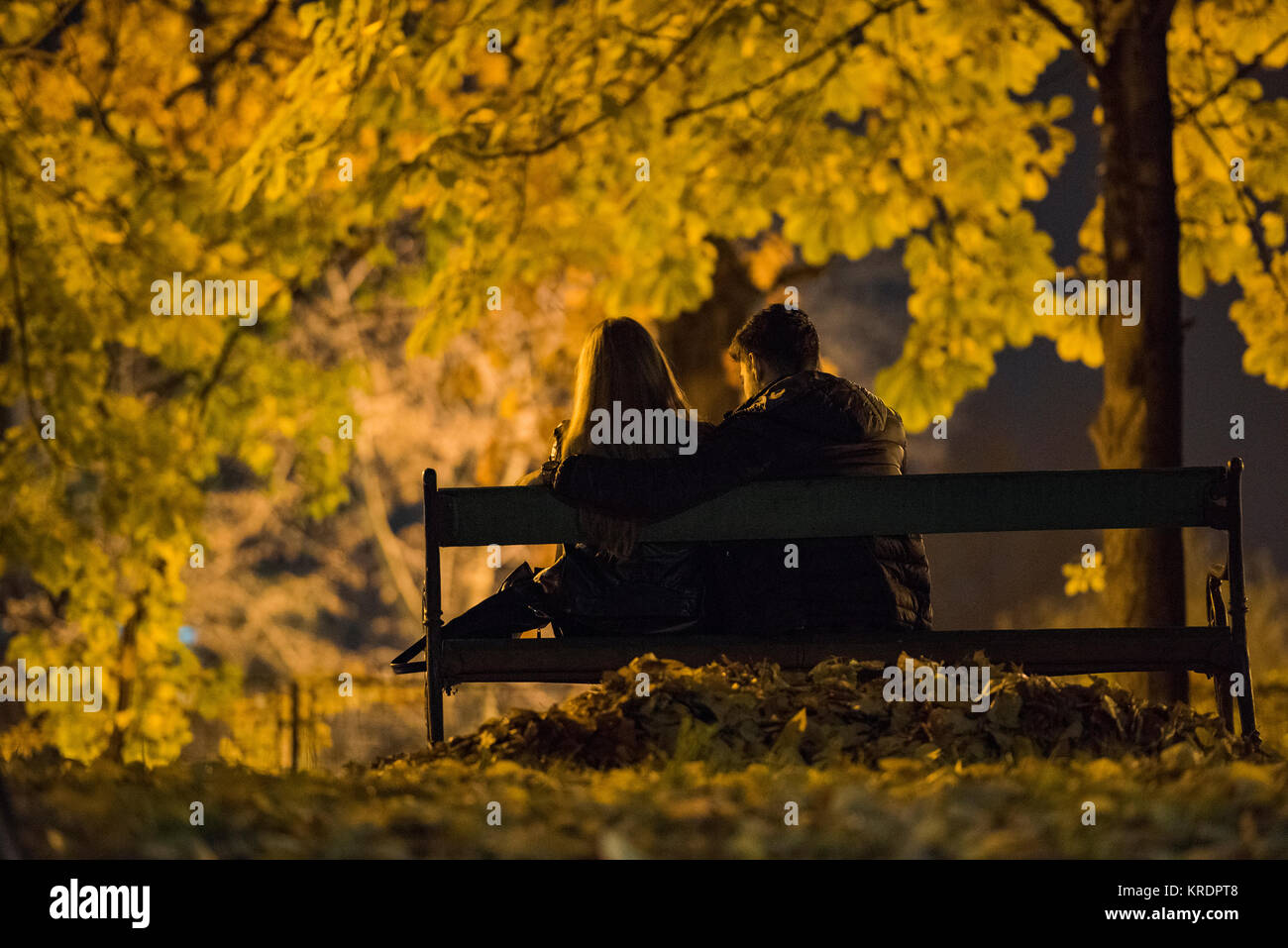 Couple sur un banc dans une soirée d'automne Banque D'Images