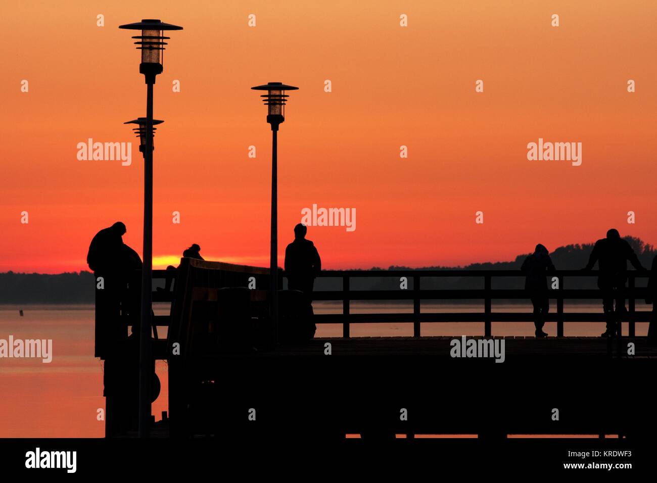 Les gens sur le pont au lever du soleil Banque D'Images