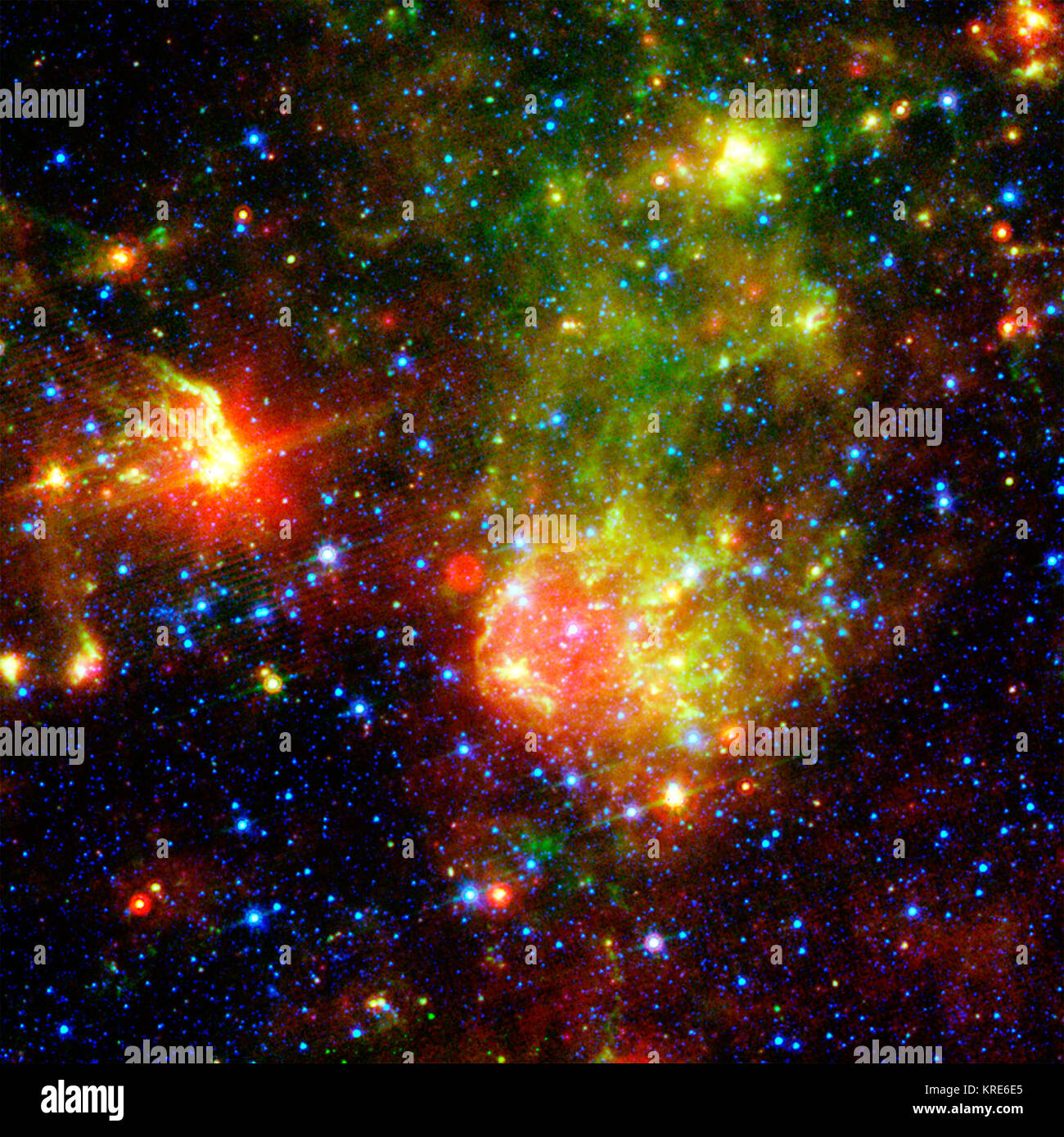 La supernova remnant 1E0102.2-7219 est assis à côté de la nébuleuse N76 dans un cadre lumineux, région d'étoiles en formation du Petit Nuage de Magellan, une galaxie satellite de notre galaxie à environ 200 000 années-lumière de la Terre. Une supernova remnant est composé des bits malpropre et pièces d'une étoile massive qui a explosé, ou est allé supernova. L'image montre des grains de poussière rougeoyante dans trois longueurs d'onde du rayonnement infrarouge : 24 microns (rouge) mesurée par le photomètre multibande imaging à bord au télescope spatial Spitzer de la NASA ; et 8,0 microns (vert) et 3,6 microns (bleu) mesurée par l'appareil photo infrarouge de Spitzer Banque D'Images