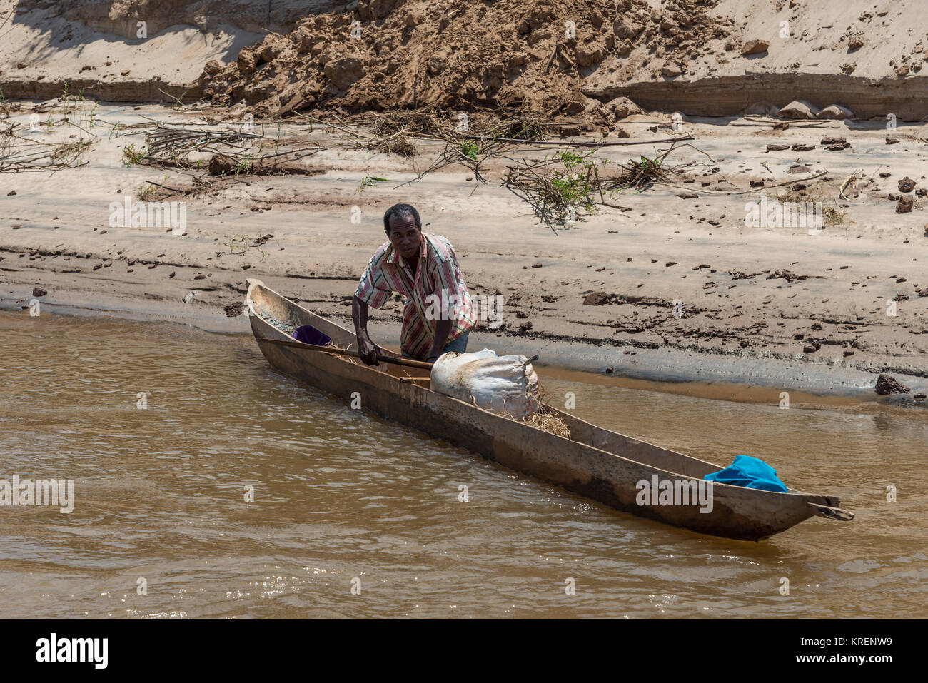 Un homme et sa pirogue sur la rivière Mania. Madagascar, l'Afrique. Banque D'Images