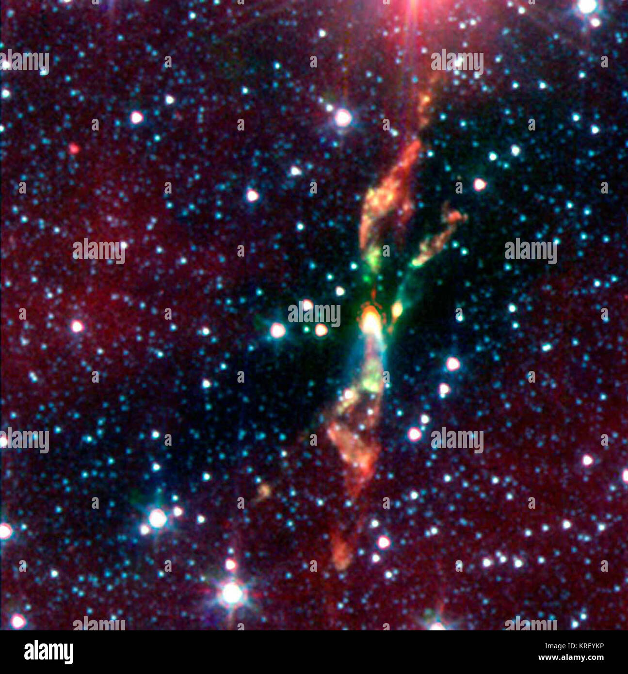 Deux jeunes étoiles exubérant détruisent leur thème nuage de poussières grâce à de puissants jets de radiations, dans une image infrarouge du télescope spatial Spitzer de la NASA. Les étoiles sont situées à environ 600 années-lumière dans un nuage cosmique appelé BHR 71. En lumière infrarouge, la baby stars sont indiquées comme les taches jaune vif vers le centre. Ces deux taches jaunes ont traînées de tir vert hors d'eux. Les feux follets verts révèlent le début d'un jet. Comme un arc-en-ciel, le jet commence comme vert, puis passe à l'orange et rouge vers la fin. La jets en modifiant les couleurs, révèle une FEP de refroidissement Banque D'Images