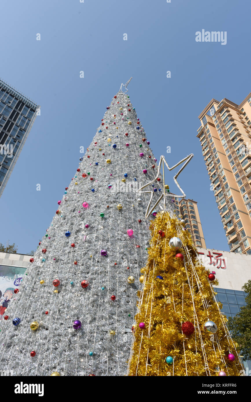 21 décembre 2017, Mianyang, Sichuan, Chine. Malgré les réserves des ministères du gouvernement sur les festivals étrangers cette année, les entreprises sont encore dans l'espoir de créer un quartier animé de jour de Noël à relancer la consommation motivées par des intérêts commerciaux. La photo montre un immense arbre de Noël produites devant un local RT-Mart. Banque D'Images