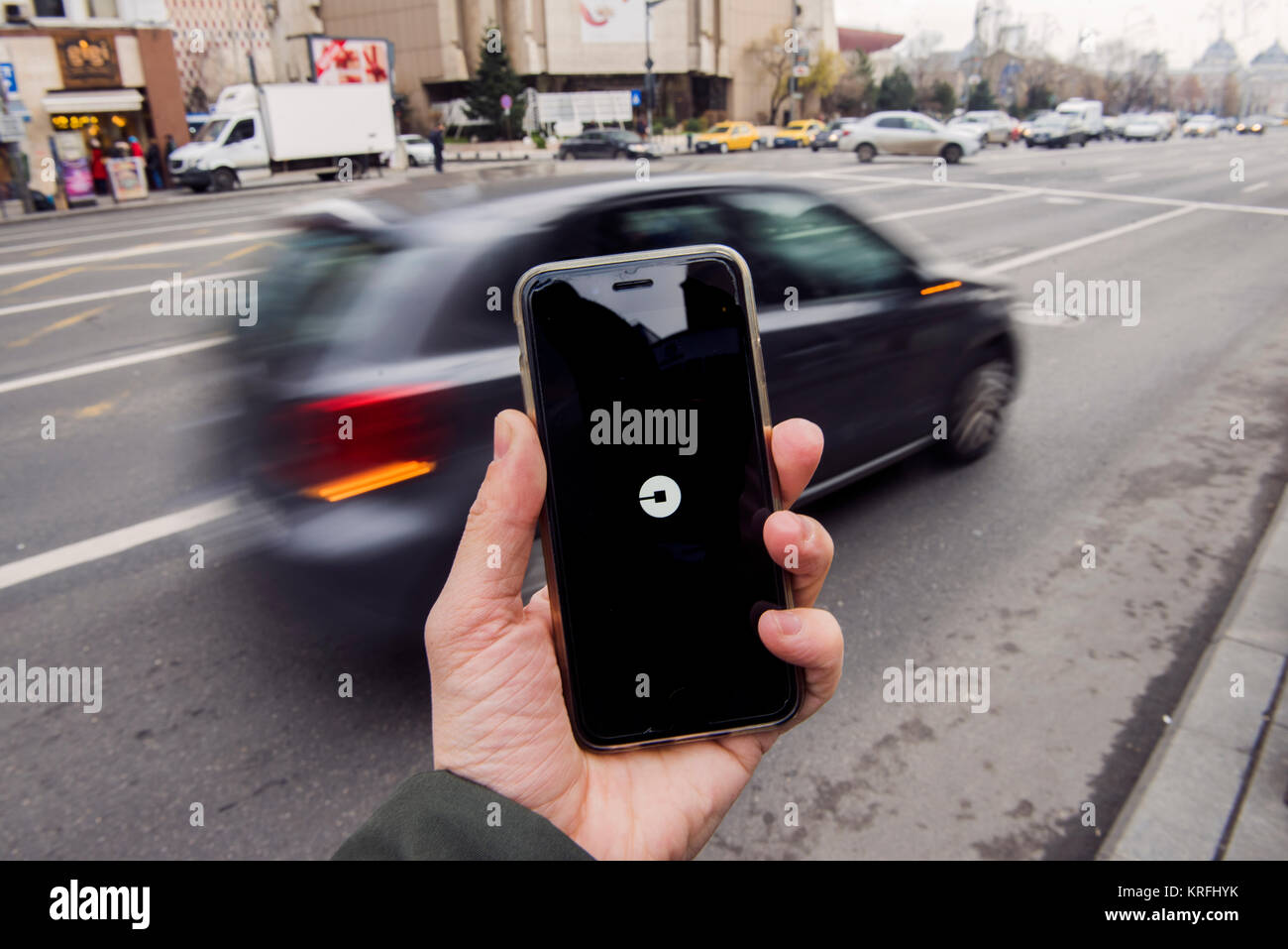 Bucarest, Roumanie - 20 décembre 2017 : Man holding a smart phone avec l'application Uber, ouvrir et en attente d'une voiture. Banque D'Images
