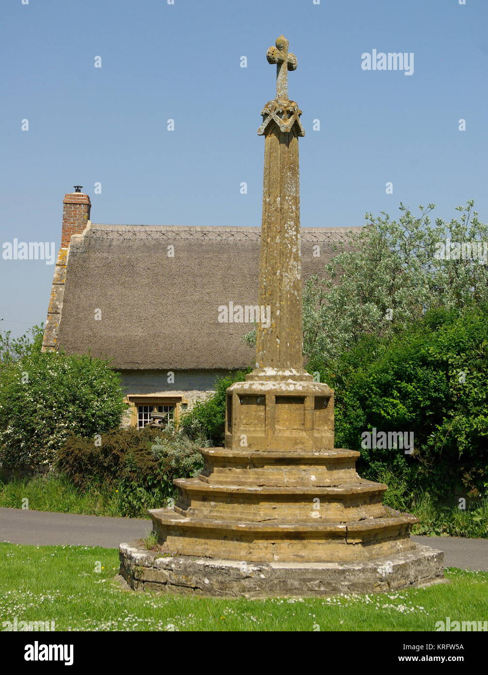 Croix de village datant du 15ème siècle dans le village de Muchelney, Somerset. La maison du curé est visible en arrière-plan. Date : 2014 Banque D'Images
