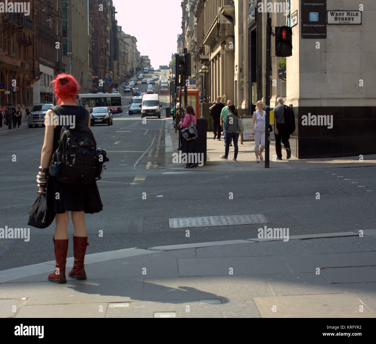 Fille femme étrange sur coin de rue avec les cheveux rouges qui marchent tous les jours ensoleillés scène de rue britannique Gordon Street Glasgow Banque D'Images