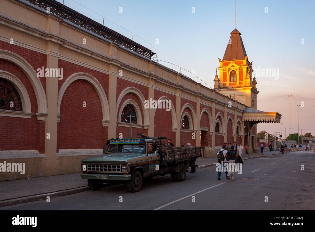 Les gens qui marchent et les croisements de rue à côté Estacao da Luz (Luz Station) gare durant le coucher du soleil, Sao Paulo, Brésil Banque D'Images