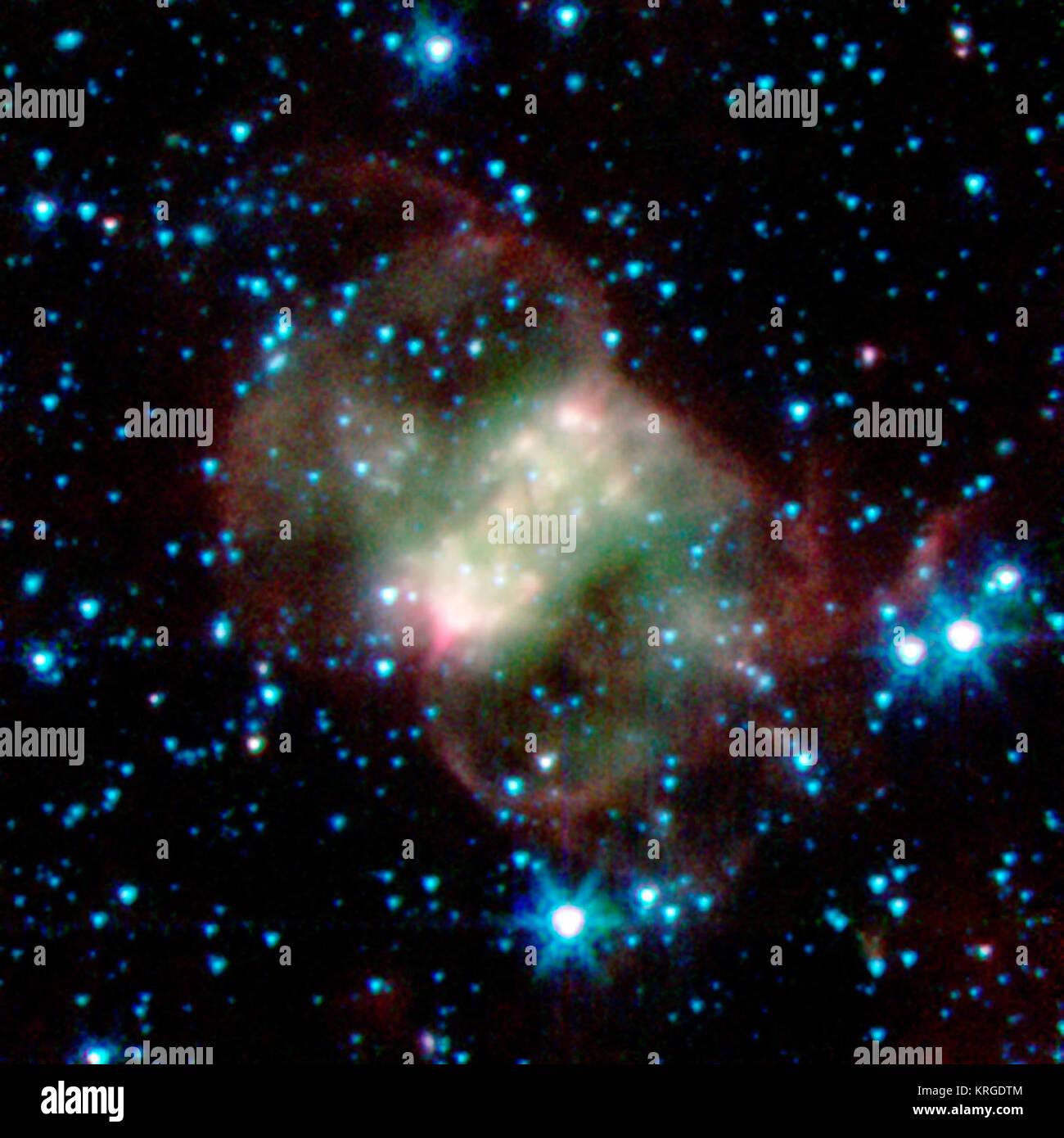 Cette nébuleuse planétaire, appelée NGC 650 ou le peu d'haltère, est à environ 2 500 années-lumière de la terre dans la constellation de Persée. Contrairement aux autres nébuleuses sphériques, il a une forme de papillon ou bipolaire en raison d'un 'taille', ou d'un disque, d'épaisseur de matériel, allant du coin inférieur gauche au coin supérieur droit. Le vent souffle rapide matériaux du star, au-dessus et au-dessous de ce disque poussiéreux. Les nuages rouges et verts macabre de molécules d'hydrogène sont lumineux, avec la zone verte étant plus chaud que le rouge. Dans cette image, lumière infrarouge à des longueurs d'onde de 3,6 microns est rendue en bleu, 4,5 microns en vert, et 8,0 mi Banque D'Images
