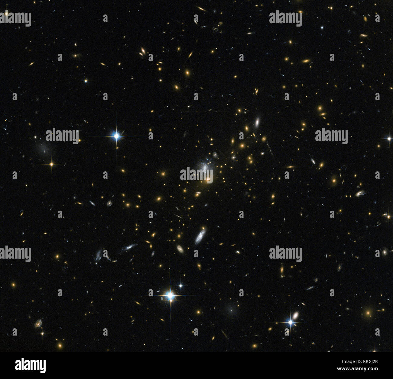 Les amas de galaxies sont parmi les plus massives des structures qui peuvent être trouvés dans l'univers - les grands groupes de galaxies liées par la gravité. Cette image de la NASA/ESA Hubble Space Telescope révèle l'une de ces grappes, connu sous le nom de MACS J0454.1-0300. Chacun des points lumineux que l'on voit ici est une galaxie, et chacun est à la maison à beaucoup de millions, ou même des milliards d'étoiles. Les astronomes ont déterminé la masse des MACS J0454.1-0300 à environ 180 000 milliards de fois la masse du Soleil. Grappes comme ceci sont si massives que leur gravité peuvent même modifier le comportement de l'espace autour d'eux, pliant le chemin d'o Banque D'Images