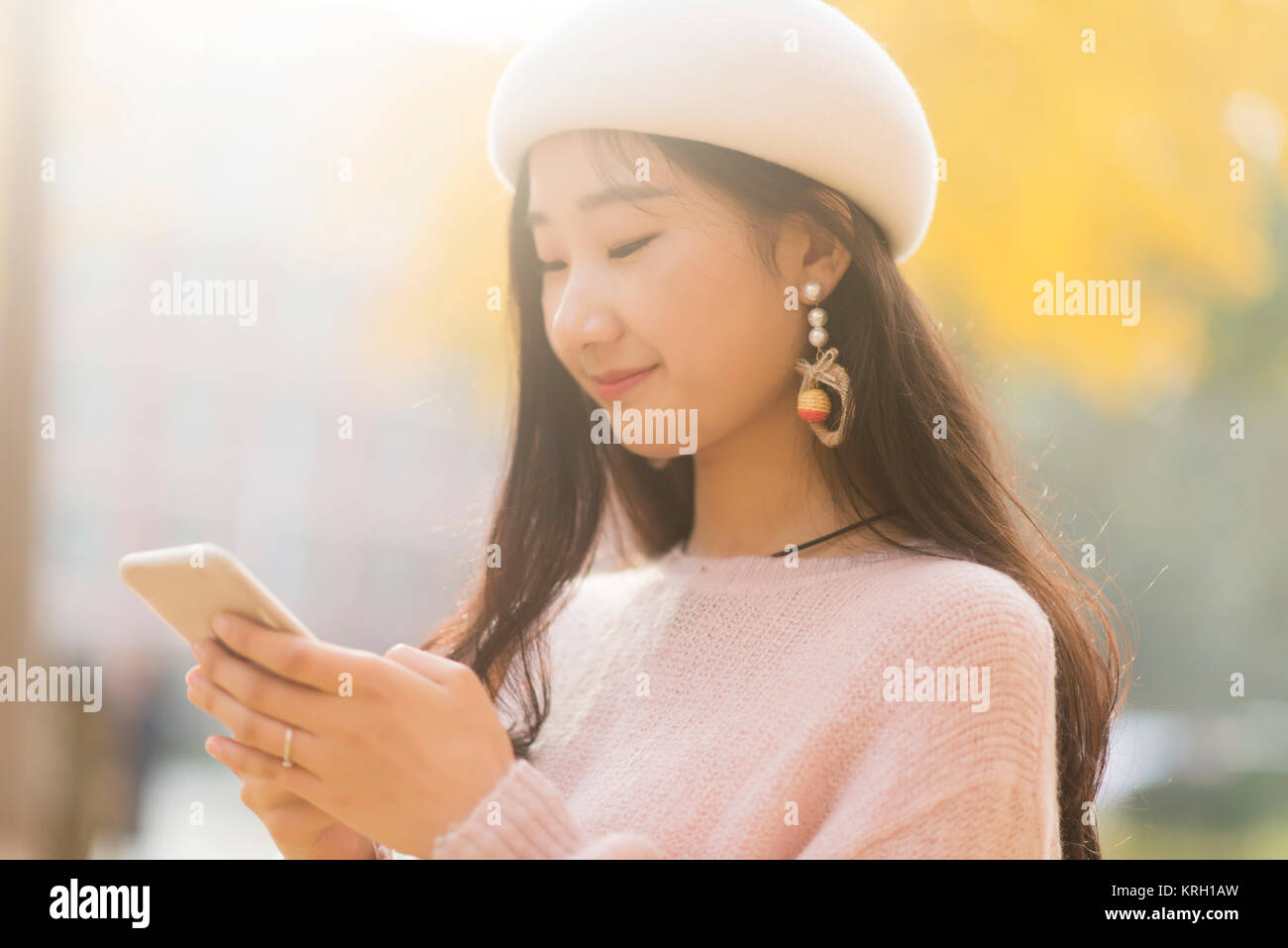 Portrait of a smiling woman texting on un jour automnes Banque D'Images