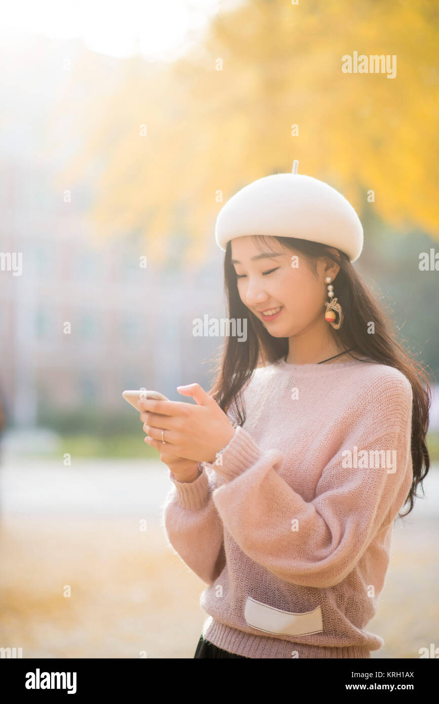 Portrait of a smiling woman texting on un jour automnes Banque D'Images