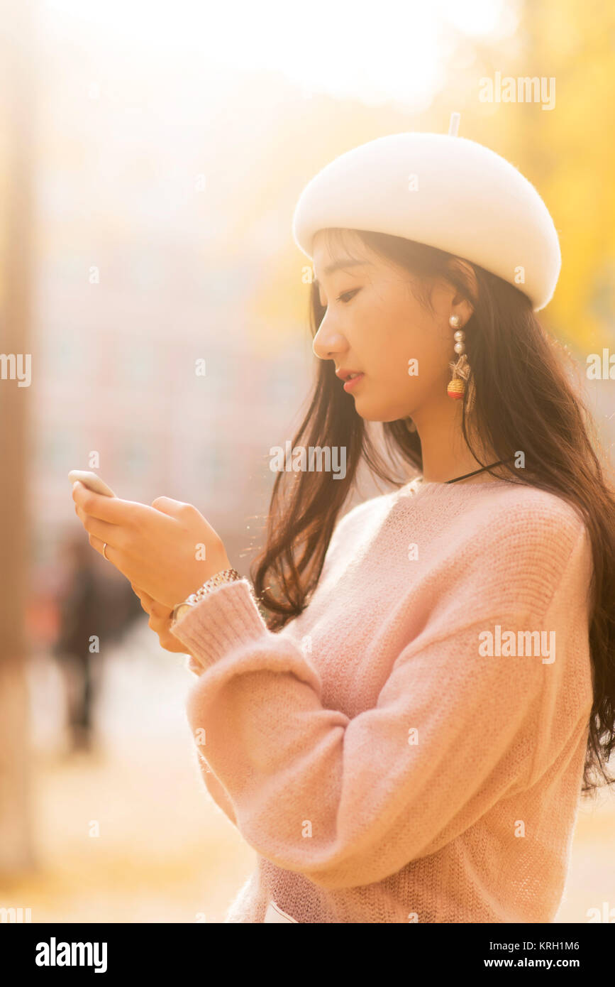 Portrait of a smiling woman texting on un jour automnes Banque D'Images