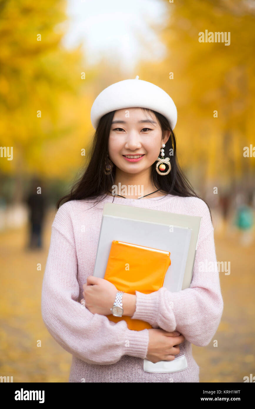 Portrait of a smiling woman reading a book on un jour automnes Banque D'Images