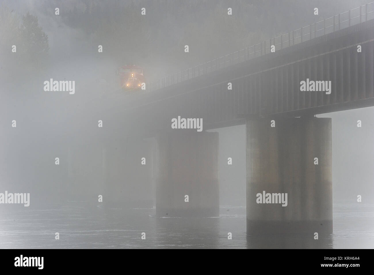 CPR Train de charbon de l'ouest dirigé par loco 9756 dans le brouillard sur le pont de la rivière Columbia à Revelstoke - BC Banque D'Images