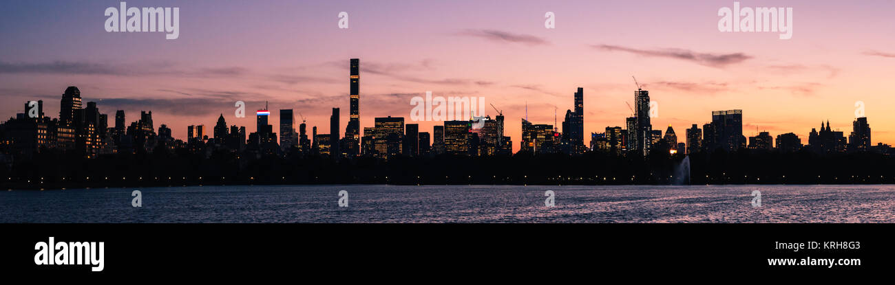 Coucher de soleil sur Midtown et Hell's Kitchen, à Manhattan, New York, USA. Vue depuis le nord à travers le Jacqueline Kennedy Onassis reservoir dans Central Park Banque D'Images