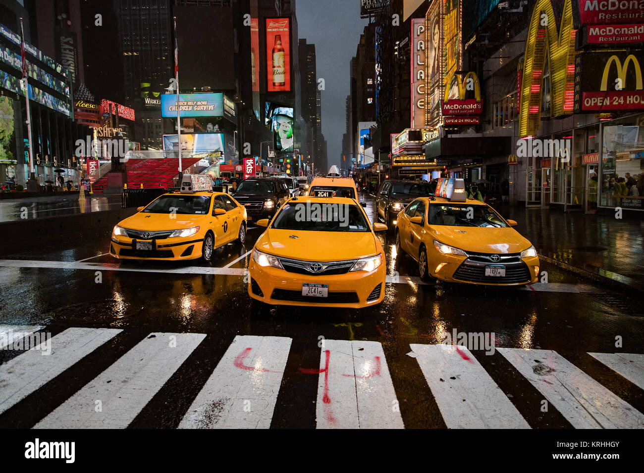 Médaillon de New York Taxi jaune jusqu'à la traversée de la ligne sur un soir de pluie à temps's Square, New York City, l'Amérique Banque D'Images