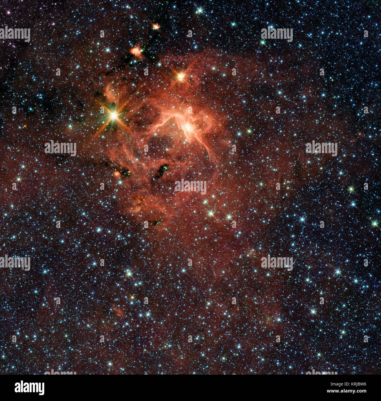 Cette région d'étoiles en formation, capturé par au télescope spatial Spitzer de la NASA, est dominé par la jeune étoile lumineuse, l'IRAS 13481-6124 (en haut à gauche), qui est environ 20 fois la masse de notre soleil et cinq fois son rayon, et il est entouré par ses pré-natal cocoon. C'est le premier bébé massive star pour les astronomes qui pouvaient obtenir un regard détaillé sur les disques poussiéreux étroitement autour de lui. La recherche fournit une preuve directe que les étoiles massives constituent de la même façon que leurs petits frères. À partir de cette image, Spitzer d'archives ainsi que des observations faites avec l'APEX 12 mètres te sous-millimétrique Banque D'Images