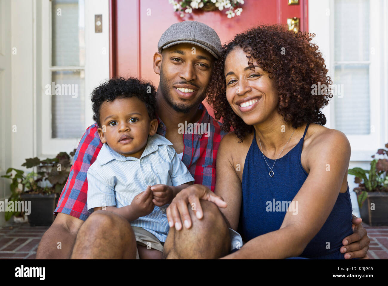 Smiling young couple sitting on/stoop avec fils Banque D'Images