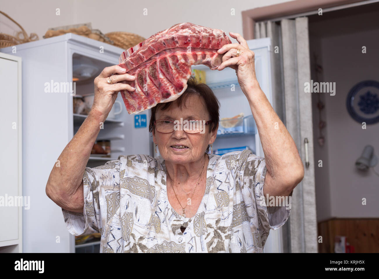 Senior woman avec des côtes de porc cru Banque D'Images