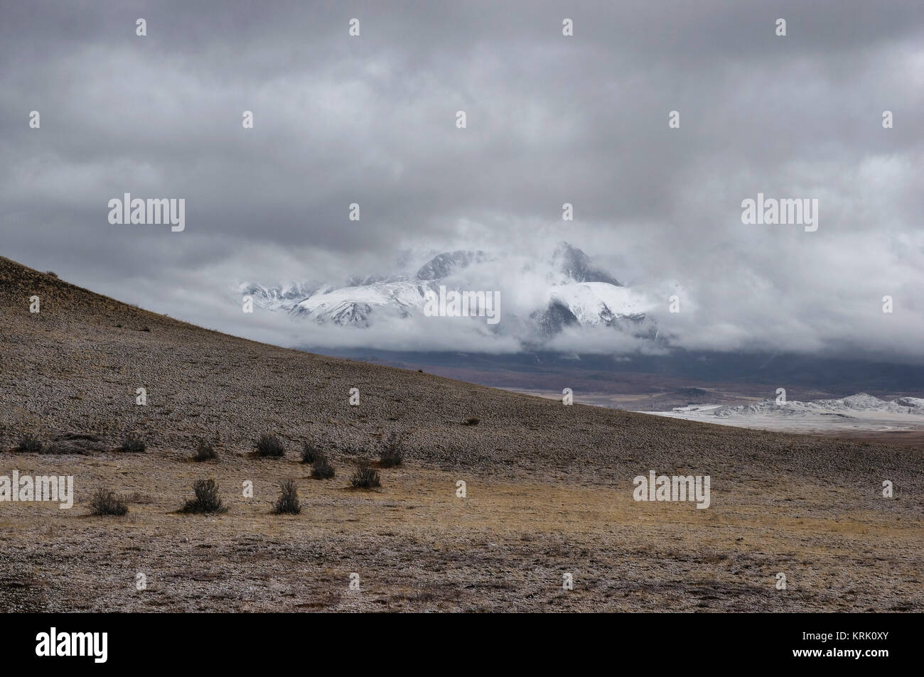 Sombre hiver spectaculaire sur une steppe désertique plateau de montagne des highlands avec gammes de neige pics sur un horizon horizon tempête Kurai Altaï Sibérie Banque D'Images