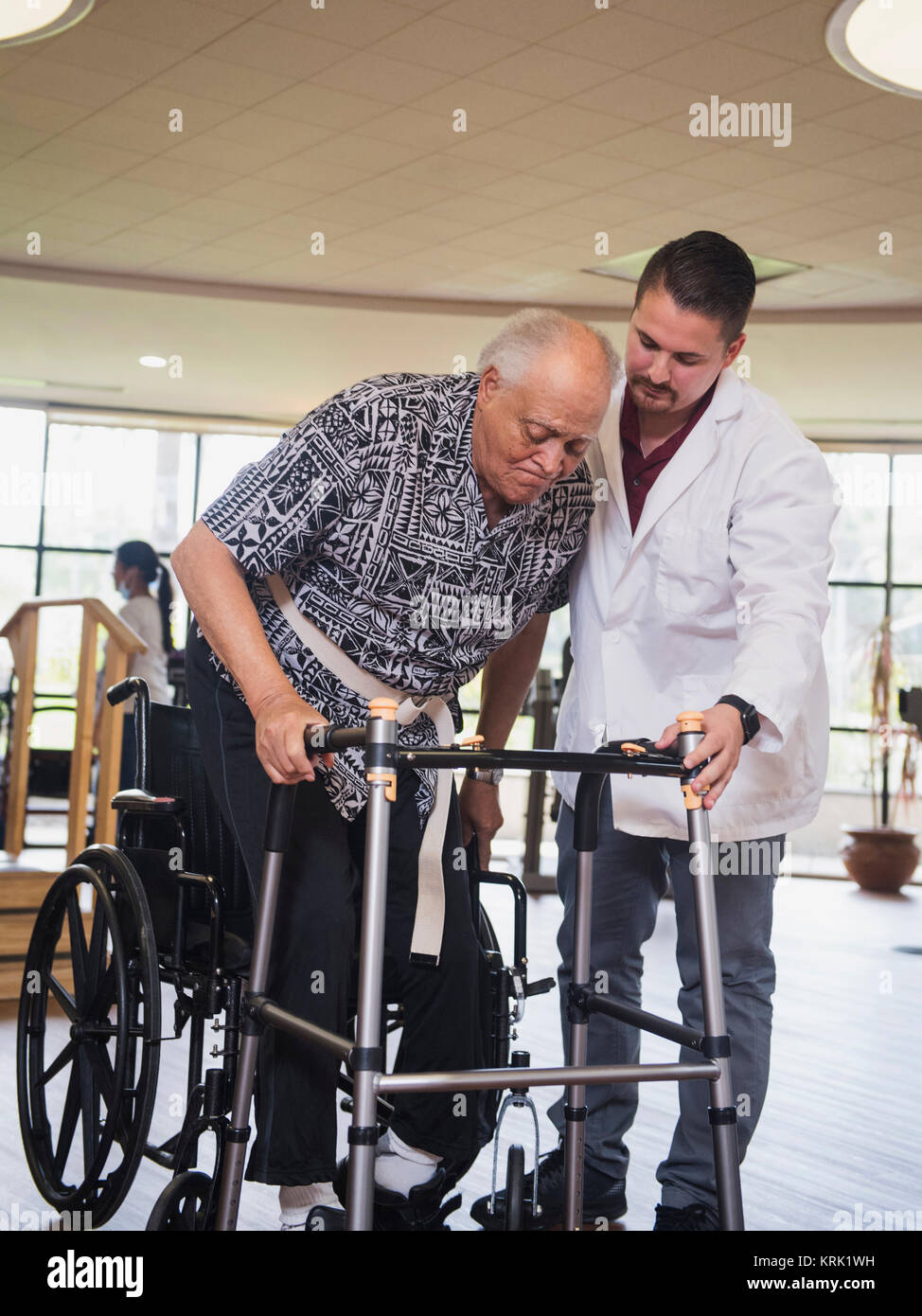 Thérapeute physique d'aider l'homme en fauteuil roulant à l'walker Banque D'Images