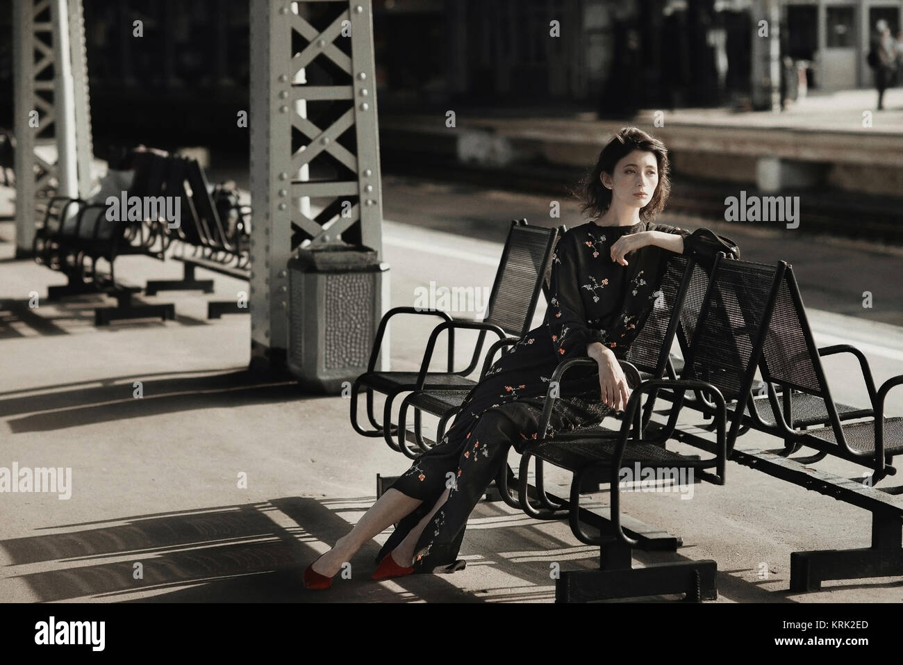 Caucasian woman sitting on bench at train station Banque D'Images