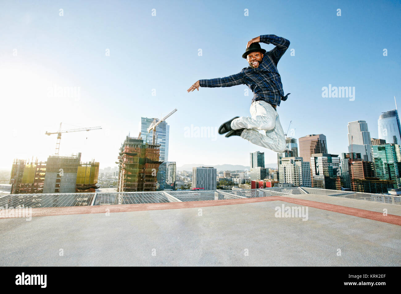 Black man dancing et le saut on urban rooftop Banque D'Images