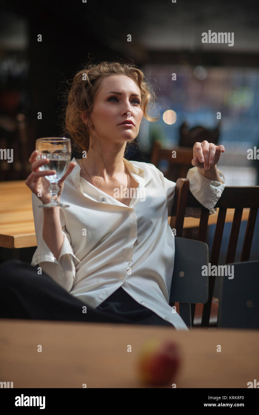 Caucasian woman sitting at table l'eau potable Banque D'Images