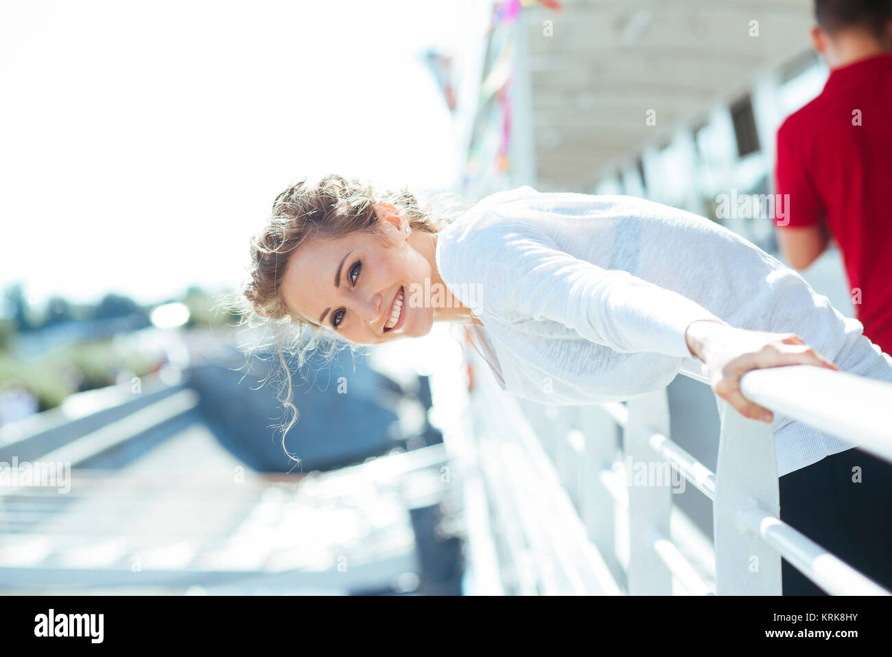 Smiling Caucasian woman leaning over railing Banque D'Images