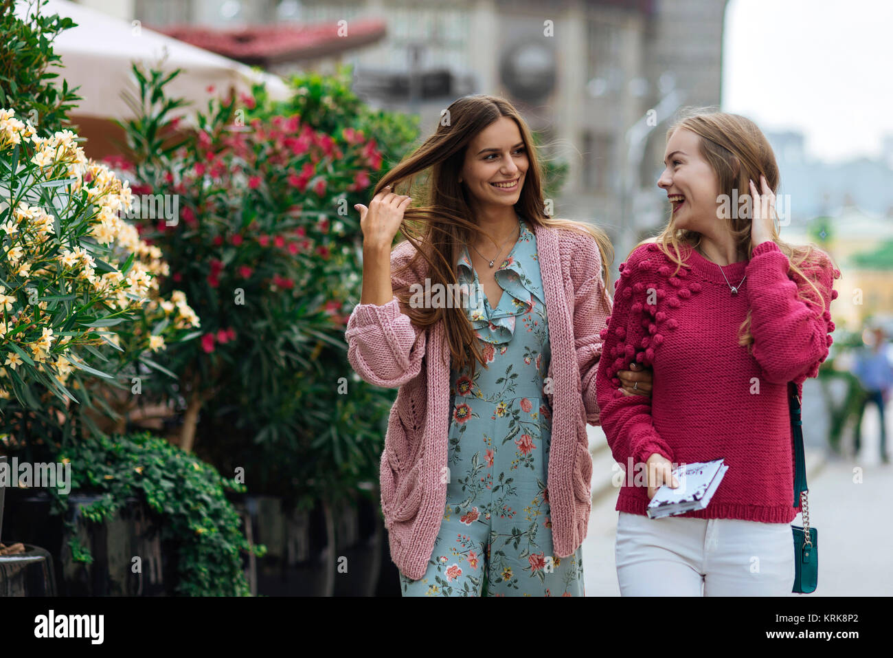 Smiling Caucasian women walking avec les mains dans les cheveux Banque D'Images