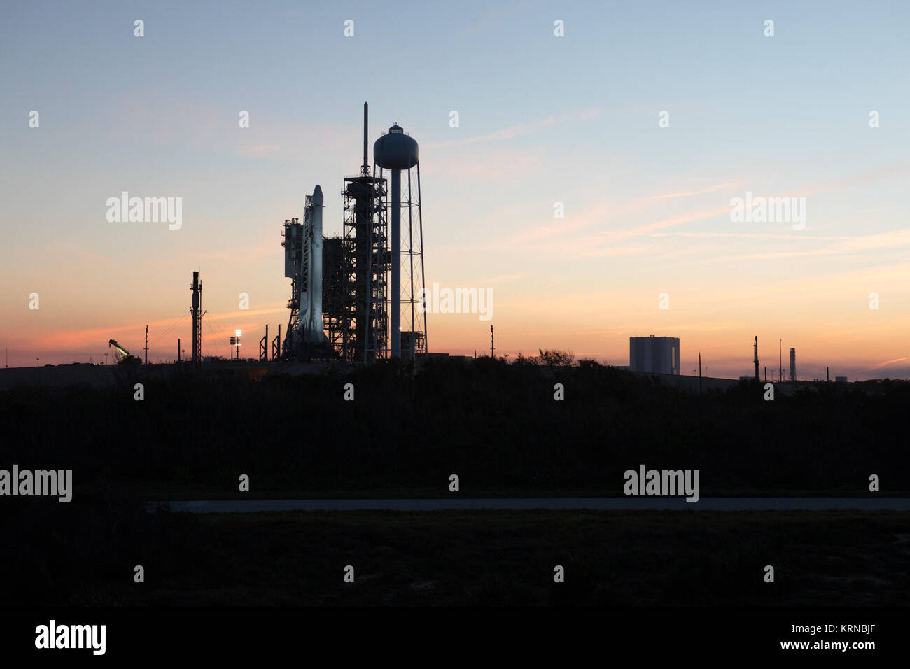 Comme le soleil se couche, une fusée Falcon 9 est prête pour le décollage au Kennedy Space Center Lancement du complexe 39A. Le lancement historique site est maintenant exploité par SpaceX en application d'un accord signé avec la NASA. Dans l'arrière-plan est le véhicule du bâtiment des Assemblées. La fusée va stimuler un vaisseau de ravitaillement de dragon à la Station spatiale internationale. Le décollage est prévu pour 10 h 01 HNE le 18 février. Sur ses 10 services d'approvisionnement commercial mission à la station spatiale, Dragon, 5 000 livres de fournitures telles que le gaz et aérosols stratosphériques Experiment (SAGE) III instrument pour de plus amples stu Banque D'Images