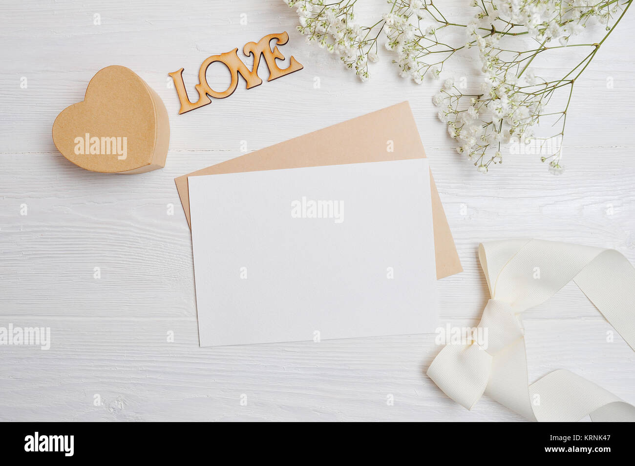 Maquette lettre avec un amour fort en forme de cœur se trouve sur un tableau blanc en bois avec fleurs de gypsophile, une carte de vœux pour le jour de Valentine avec Banque D'Images