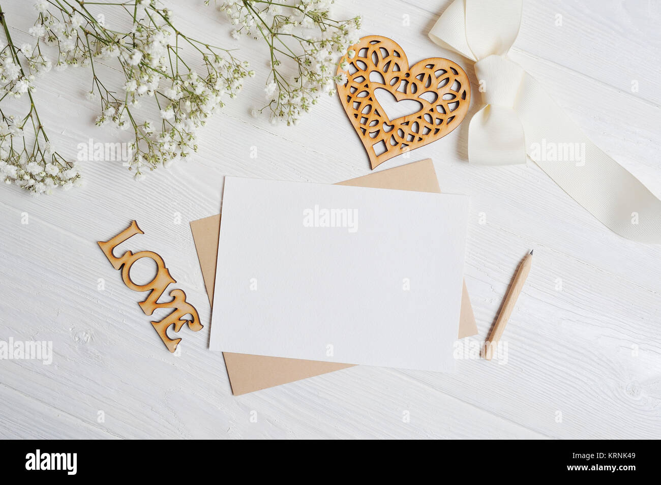 Maquette lettre avec un amour fort en forme de cœur se trouve sur un tableau blanc en bois avec fleurs de gypsophile, une carte de vœux pour le jour de Valentine avec Banque D'Images