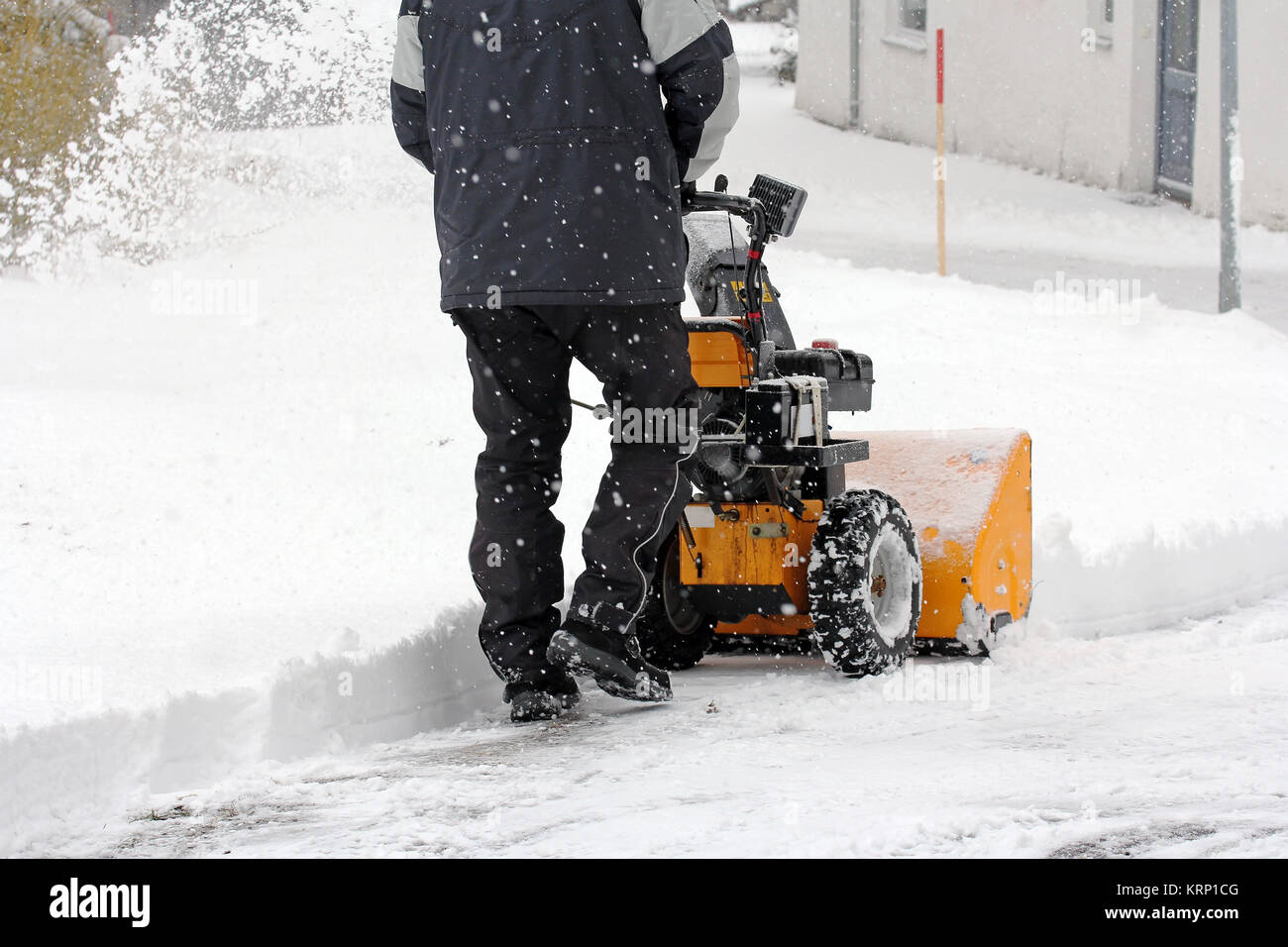 Un homme avec une souffleuse à neige neige admet Banque D'Images