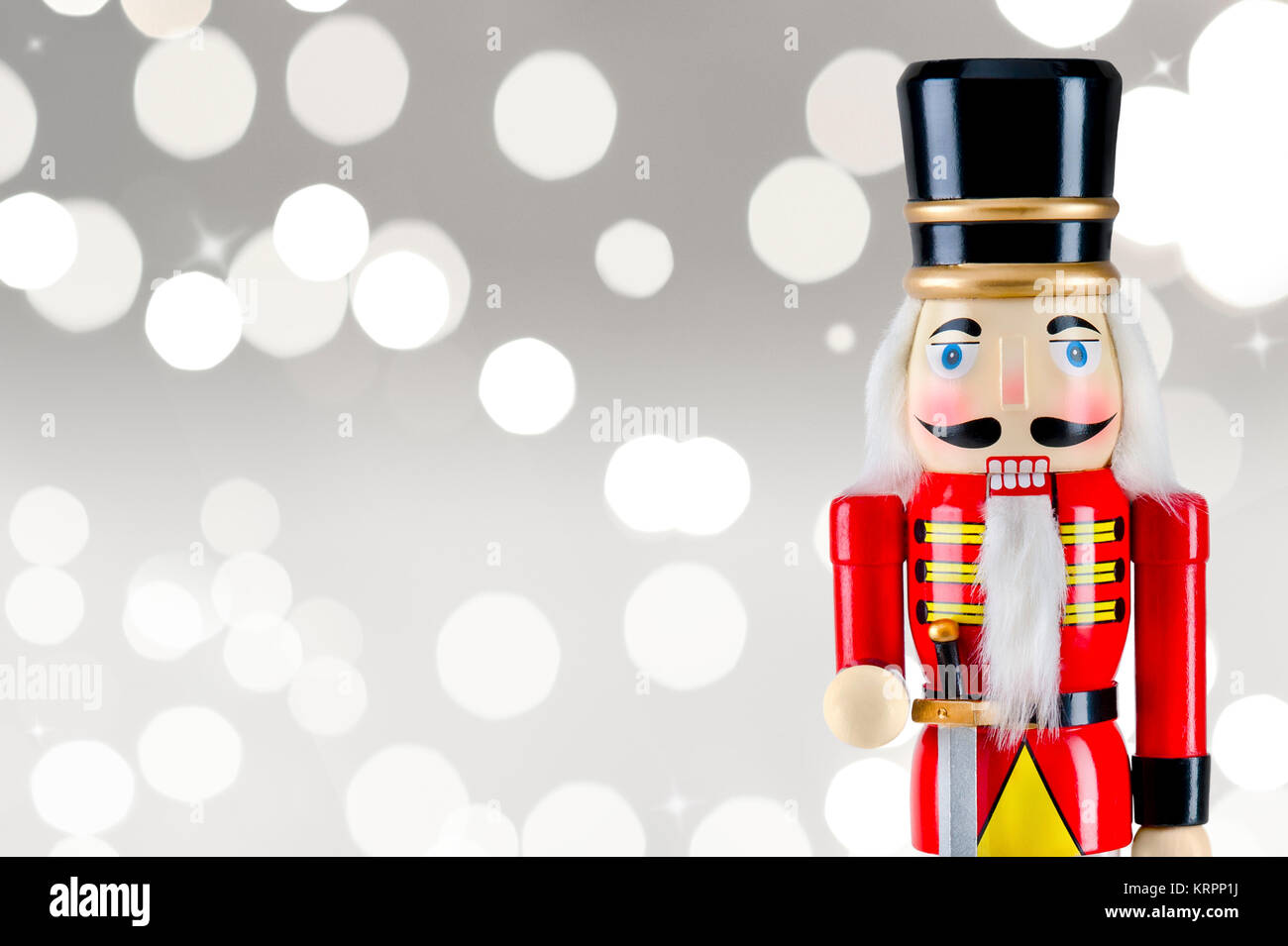 Casse-noisette soldat statue debout devant des lumières de Noël Banque D'Images