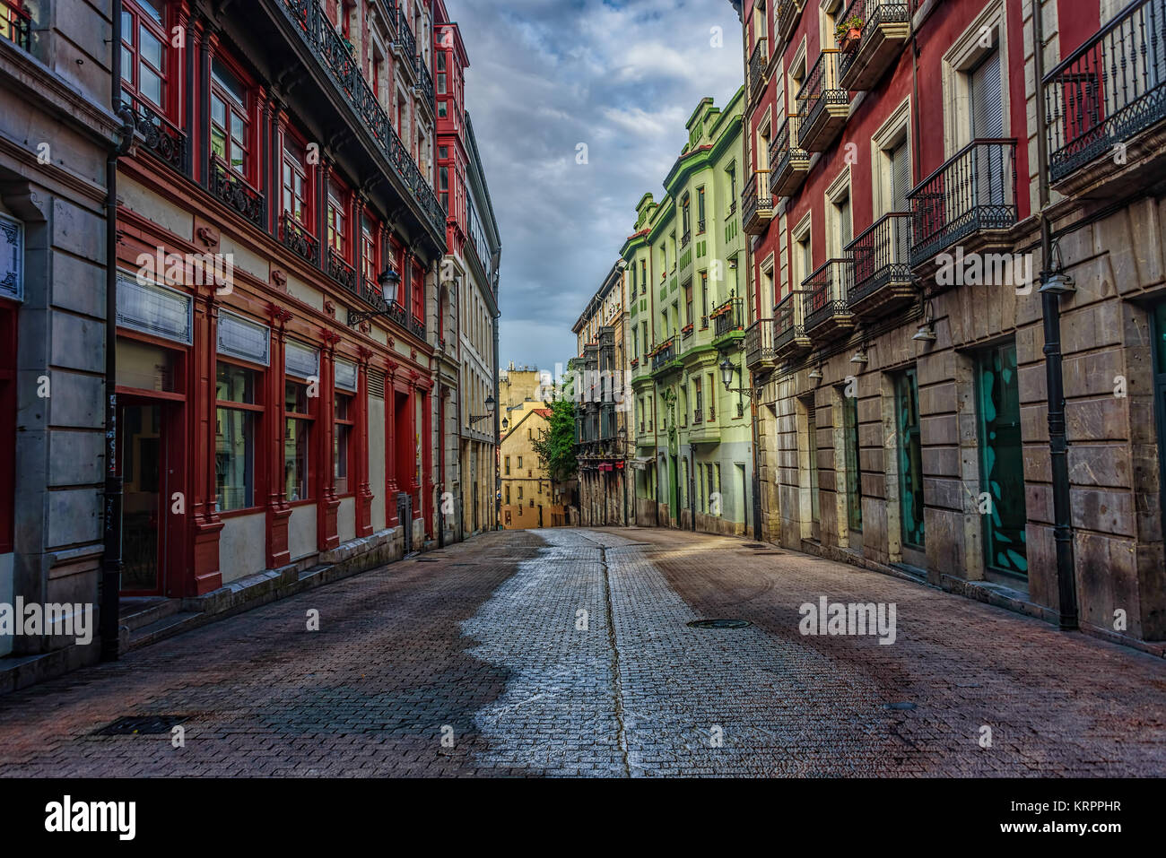 La rue vide avec de vieux bâtiments colorés au petit matin sous ciel nuageux Banque D'Images
