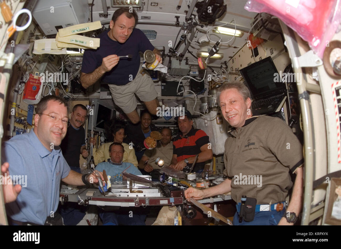 Station spatiale internationale La NASA Navette spatiale Discovery STS-116 mission premier membre d'équipage de l'astronaute américain Nicholas Patrick (à gauche), les membres de l'équipage Expédition 14 premier astronaute américain Michael Lopez-Alegria, et l'Allemand Thomas Reiter, astronaute de l'Agence spatiale européenne partagent un repas dans le module de service Zvezda de l'ISS le 13 décembre 2006, l'orbite de la Terre. Banque D'Images
