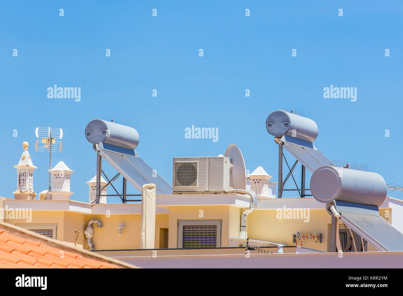 Collecteurs solaires et chaudières avec airco sur toit de maison Banque D'Images