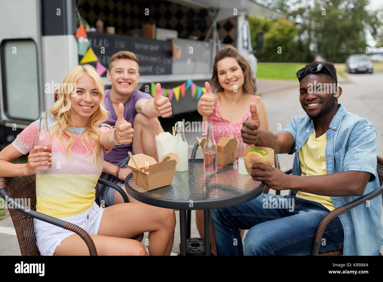 Happy friends avec boissons manger au camion alimentaire Banque D'Images