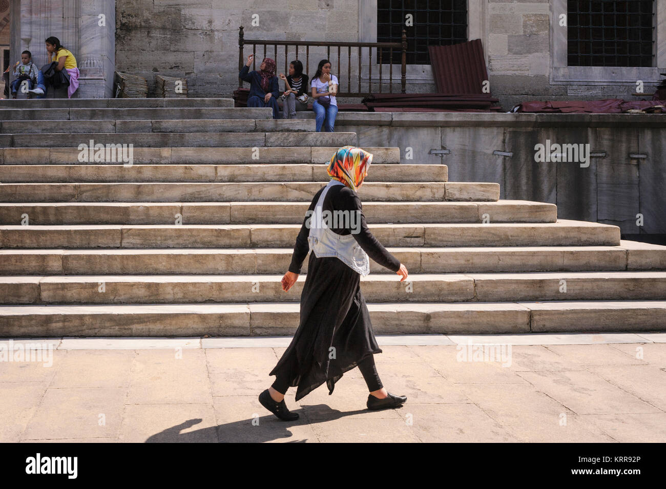 Turkish woman wearing headscarf marcher le long passé rue escalier d'une mosquée à Istanbul Turquie Banque D'Images