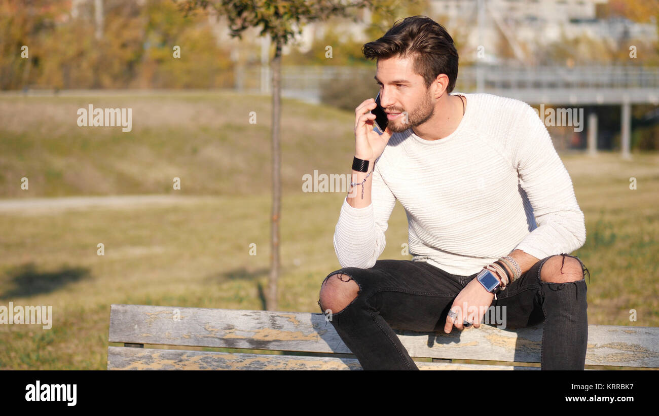 Bel homme faisant appel à l'extérieur sur l'environnement urbain avec cell phone Banque D'Images