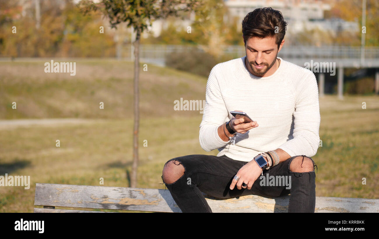 Bel homme faisant appel à l'extérieur sur l'environnement urbain avec cell phone Banque D'Images