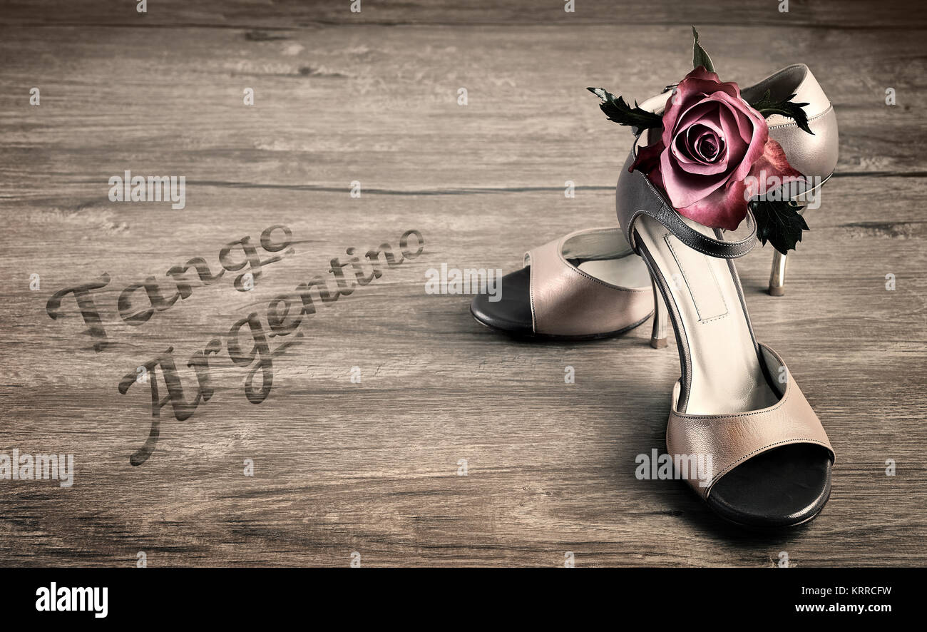 Chaussures de tango argentin et une rose sur un plancher en bois, légende "Tango Argentino". Cette image est tonique. Banque D'Images