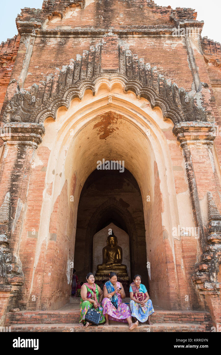Trois femmes birmanes âgés assis devant le temple Dhammayangyi à Bagan, Myanmar (Birmanie), du point de vue de l'avant. Banque D'Images