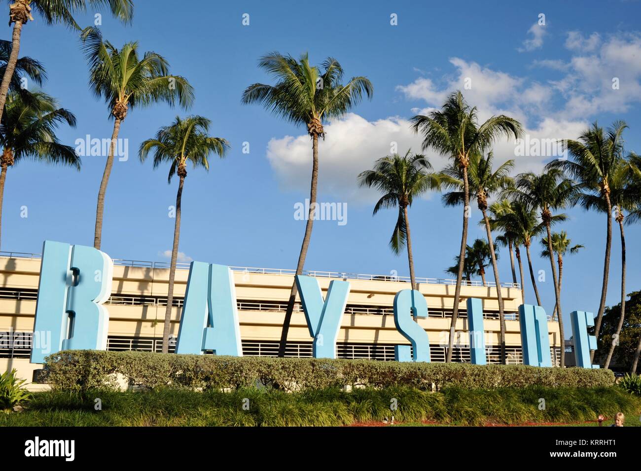 Bayside signe avec palmiers tropicaux, ciel bleu et édifices urbains, en dehors du marché Bayside à Miami, Floride, USA. Banque D'Images