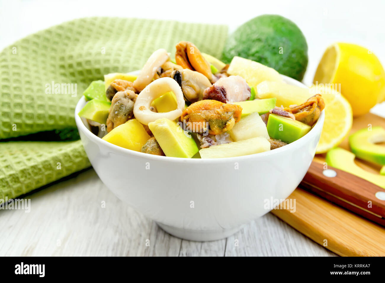 Salade avec des fruits de mer et de citron dans un bol sur le conseil de la lumière Banque D'Images